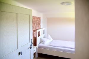 Habitación pequeña con cama y puerta de cristal en Ferienhaus Rabenbrunn, en Arnstorf