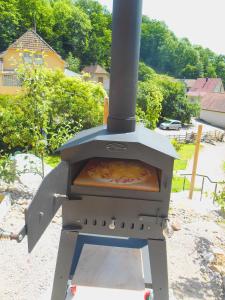 Eine Pizza kocht in einem Außenofen in der Unterkunft Gite du Walsbach in Munster