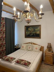 a bedroom with a bed with two pillows and a chandelier at Casa Rosca in Sighişoara