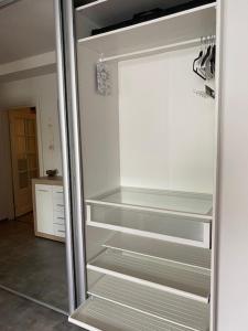 a white refrigerator with empty shelves in a kitchen at Viihtyisä ja rauhallinen keskustan tilava kaksio in Turku