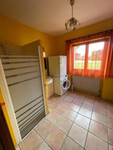 uma pequena cozinha com um frigorífico e uma janela em le Pigeonnier gersois em Condom