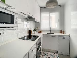 a white kitchen with a sink and a microwave at Piso céntrico en Tarragona in Tarragona