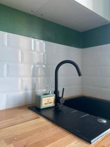 a kitchen sink with a clock on a counter at Appartement Centre Ville in Nevers