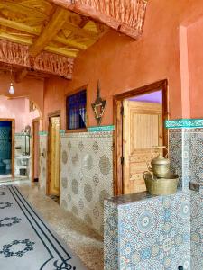 um quarto com uma mesa e uma parede com azulejos em Atlas Imsker em Marrakech