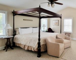 a bedroom with a canopy bed and a chair at Pheasant Field Bed and Breakfast in Carlisle