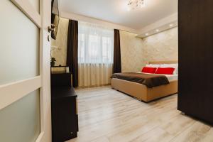 a bedroom with a bed with red pillows at Noua Oasis BNB with PARKING in Braşov