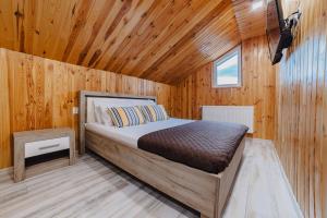 - une chambre avec un lit dans une cabane en bois dans l'établissement Noua Oasis BNB with PARKING, à Braşov