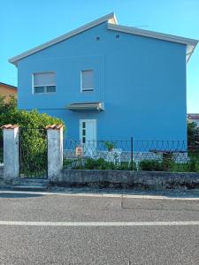 una casa azul con una valla delante en Villa Azzurra, en Monfalcone