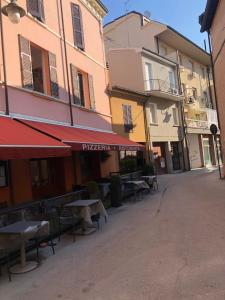 une rue vide avec des tables, des chaises et des bâtiments dans l'établissement la pigna bizantina, à Ravenne