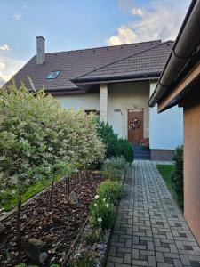 a house with a walkway in front of a yard at Ubytovanie na súkromí in Veľká Lomnica