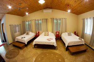 a room with two beds in a room with windows at Soul Sync Sanctuary formally Hacienda la Moringa in Playa Hermosa