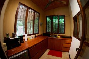 a kitchen with a counter with a sink and windows at Soul Sync Sanctuary formally Hacienda la Moringa in Playa Hermosa