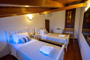 Habitación con 2 camas en una habitación en REALE - Art Luxury Villa, en Mitikas