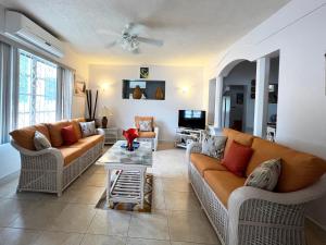 uma sala de estar com dois sofás e uma mesa em ZenBreak Graceville BeachHouse em Saint James
