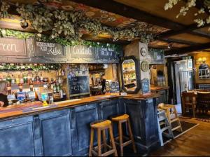un bar con taburetes de madera en un restaurante en Suburban 2-bed, entire home, free parking, Maidstone, Kent UK en Boxley