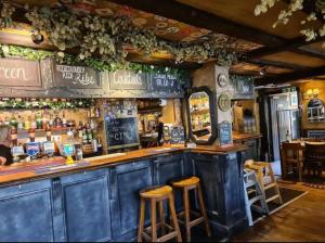 a bar with wooden stools in a restaurant at Suburban 2-bed, entire home, free parking, Maidstone, Kent UK in Boxley