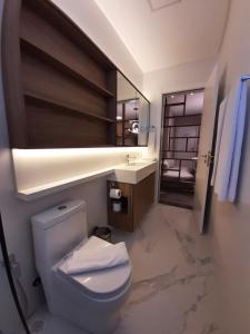 ein Badezimmer mit einem WC, einem Waschbecken und einem Spiegel in der Unterkunft I Am Design Hotel Itapema by Hotelaria Brasil in Itapema