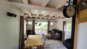 a living room with a table and a clock at La Grange in Auberville +22 photos