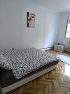 ein großes Bett in einem Zimmer mit Holzboden in der Unterkunft APARTMAN MARKOVIC in Loznica