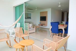 uma sala de estar com cadeiras, uma mesa e uma televisão em Magico Apartamento Frente al Mar 3 Habitaciones TR21 em Coveñas