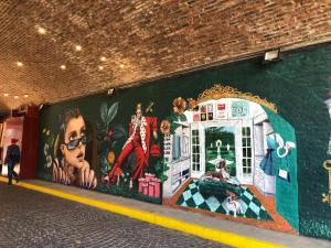 a mural on the side of a wall in a subway at El Patio Suites en Palermo Hollywood in Buenos Aires