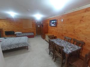 Habitación con 2 camas, mesa y sillas en Ayre Sureño en Río Gallegos