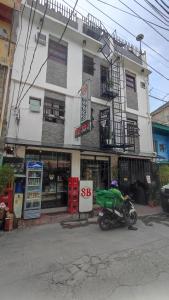Ein Mann auf einem Motorrad parkte vor einem Gebäude in der Unterkunft SB LODGE TAGUIG in Manila