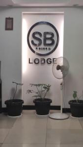 un magasin avec un logo sb sur un mur avec des plantes dans l'établissement SB LODGE TAGUIG, à Manille