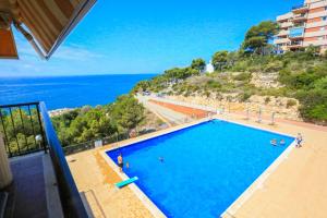 a swimming pool with the ocean in the background at CABO Palos 4 2 2 ONLY FAMILIES in Salou