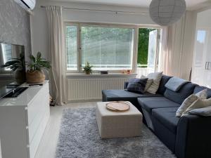 a living room with a blue couch and a window at Tilava yksiö keskeisellä sijainnilla Kuopiossa in Kuopio