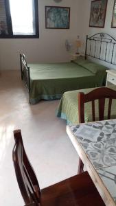 een kamer met 2 bedden en een tafel en stoelen bij Confortevole allogio ad otranto in Martano