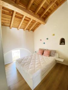 埃武拉的住宿－Casa do Contreyras，一间带白色床铺的卧室,位于带木制天花板的客房内。