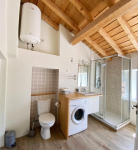 a bathroom with a toilet and a washing machine at Casa do Contreyras in Évora