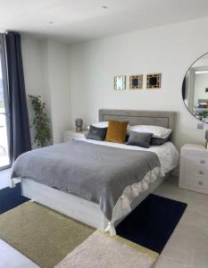 a bedroom with a large bed with pillows and a mirror at Ardwyn Studio Apartments Gibraltar in Gibraltar