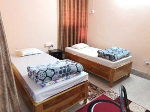 - une chambre avec 2 lits dans l'établissement Ananya Homestay, à Patna