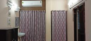 a bathroom with a shower curtain and a toilet at Ananya Homestay in Patna