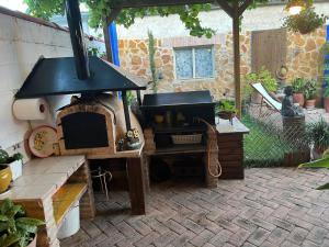 El CampoにあるCasa Rural de La Vegaのレンガ造りの庭に屋外オーブン付きのパティオ