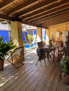 una terraza de madera con mesa, sillas y hamaca en Casa Rural de La Vega, en El Campo