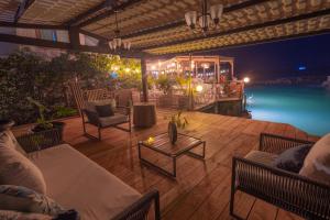 a wooden deck with chairs and a table at Blu Galapagos Sustainable Waterfront Lodge in Puerto Ayora