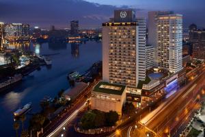 eine Skyline der Stadt in der Nacht mit einem Fluss und Gebäuden in der Unterkunft Sheraton Cairo Hotel & Casino in Kairo
