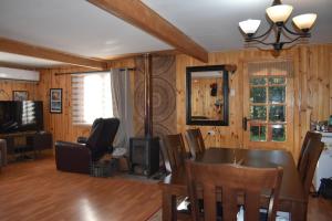 a living room with a table and chairs and a television at casa bosque in Hornopiren