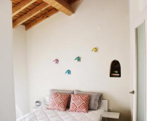 a bedroom with a bed with pink and gray pillows at Casa do Contreyras in Évora