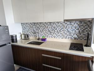 a kitchen with a sink and a counter top at Dominiks Stylish Resort Gem Ocean View Pool Queen Bed at Tambuli 8 Floor Fast Wifi in Maribago