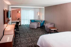 una camera d'albergo con letto, divano e scrivania di Courtyard by Marriott Albany Clifton Park a Clifton Park