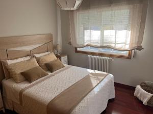 una camera con un grande letto e una finestra di Apartamento mirador de tambo a Combarro