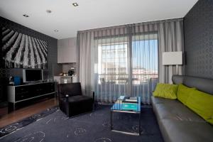 un soggiorno con divano e sedia di AC Hotel Victoria Suites by Marriott a Barcellona