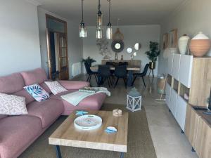 un soggiorno con divano rosa e tavolo di Apartamento mirador de tambo a Combarro
