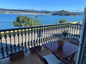 een balkon met een tafel en uitzicht op het water bij Apartamento mirador de tambo in Combarro