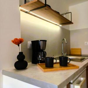 un mostrador de cocina con tres tazas de café en una tabla de cortar en nisaki rooms & apartments, en Metana