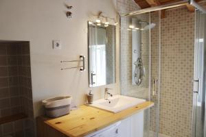 a bathroom with a sink and a shower with a mirror at Casa do Contreyras in Évora